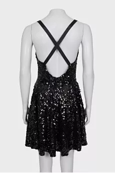 The dress is sleeveless and decorated with sequins