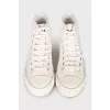 White textile sneakers with a brand logo