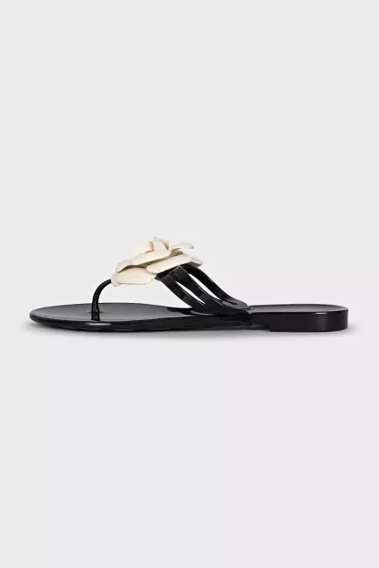 Black rubber flip-flops decorated with a flower