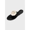 Black rubber flip-flops decorated with a flower