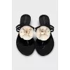 Black rubber flip-flops decorated with a flower