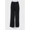 Loose trousers with a stitched crease