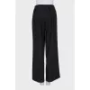 Loose trousers with a stitched crease