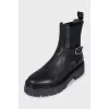 Black leather boots with a silver buckle