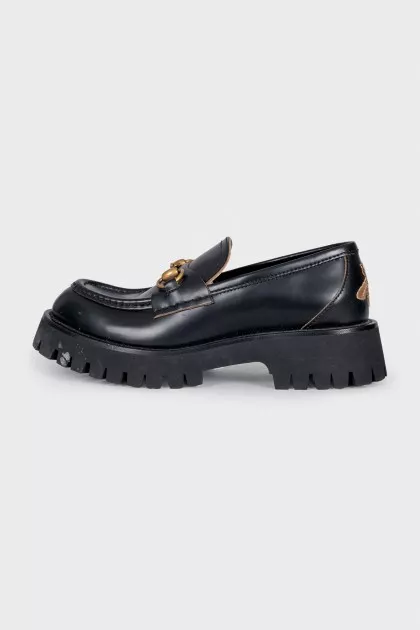Black loafers with gold decor