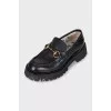 Black loafers with gold decor