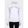 White zip-up hoodie with silver logo
