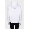 White zip-up hoodie with silver logo
