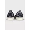 Textile slip-ons with a signature print
