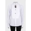 The white shirt is decorated with crystals