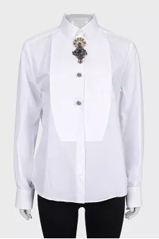 The white shirt is decorated with crystals