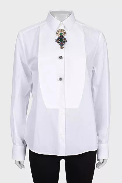 The white shirt is decorated with crystals