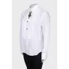 The white shirt is decorated with crystals