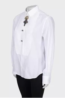 The white shirt is decorated with crystals