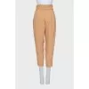 Beige tapered trousers with a belt