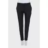 Black tapered trousers with a zip at the bottom