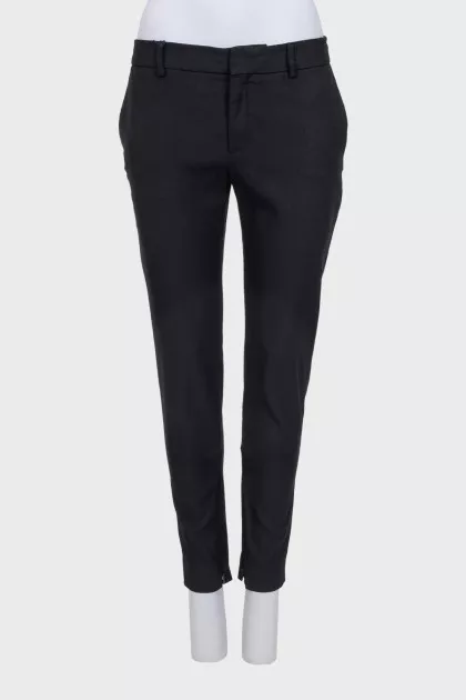 Black tapered trousers with a zip at the bottom