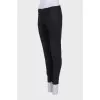 Black tapered trousers with a zip at the bottom