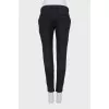 Black tapered trousers with a zip at the bottom