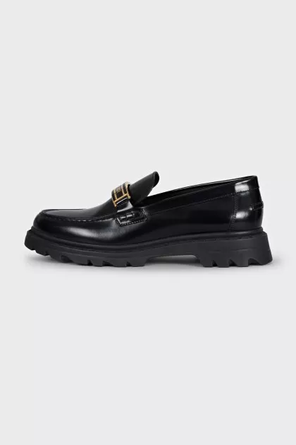 Black loafers with gold logo