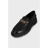 Black loafers with gold logo