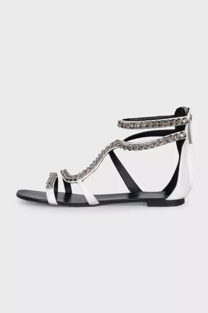 White leather sandals decorated with chains