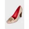 Beige leather shoes with a gold logo