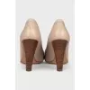 Beige leather shoes with a gold logo