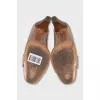 Beige leather shoes with a gold logo