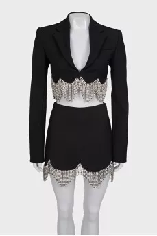 A suit consisting of a cropped jacket and a crystal-embellished skirt