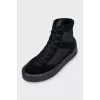 Black sneakers with suede inserts and a removable sole