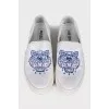 White slip-ons with branded embroidery