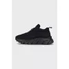 Black sneakers with a logo on a ribbed sole