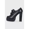 Black leather ankle boots decorated with a chain