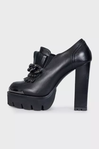 Black leather ankle boots decorated with a chain