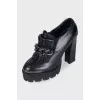 Black leather ankle boots decorated with a chain
