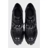 Black leather ankle boots decorated with a chain