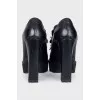 Black leather ankle boots decorated with a chain