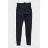 Black tapered trousers with zippers on the trousers