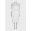 White dress with a cutout decorated with feathers