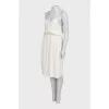 White dress with a cutout decorated with feathers