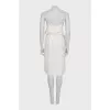 White dress with a cutout decorated with feathers