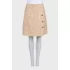 Beige tweed suit with a checkered print skirt