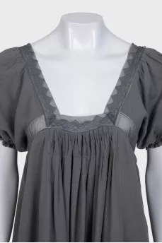 A loose-fitting dress decorated with lace