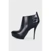 Black leather ankle boots with stiletto heels and no fastening