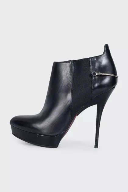 Black leather ankle boots with stiletto heels and no fastening