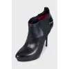 Black leather ankle boots with stiletto heels and no fastening