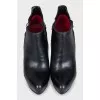 Black leather ankle boots with stiletto heels and no fastening