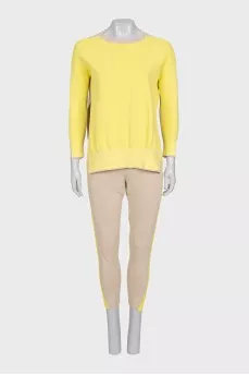 A suit consisting of a jumper with slits and trousers