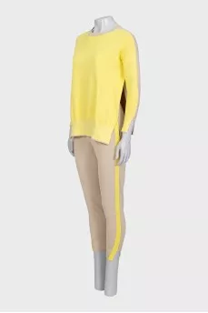 A suit consisting of a jumper with slits and trousers